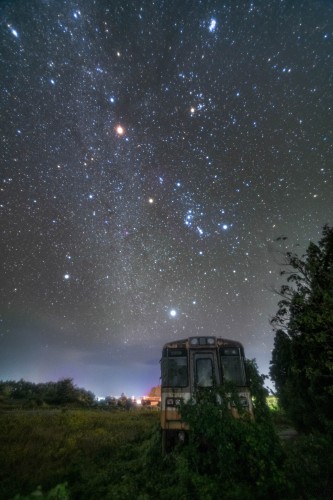 Abandoned train and shining Orion